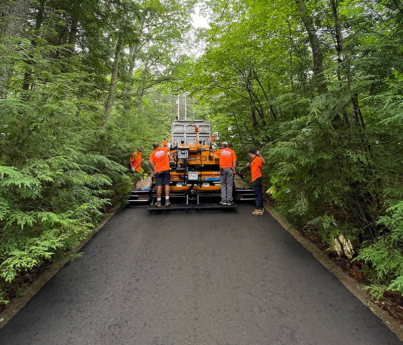 Company creating an asphalt Street in the forest